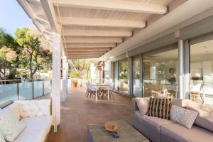 een patio met banken en een tafel en stoelen bij Villa Paraíso in Castelldefels