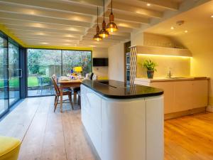an open kitchen with a table and a dining room at Betty's Cottage in Burford