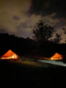 two orange tents in a field at night at Camping équipé : Vallon de Laborie in Astaillac