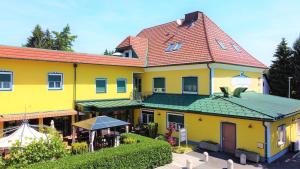 un gran edificio amarillo con techo rojo en Hotel Restaurant Neuhold, en Wagna
