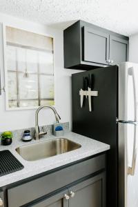 a kitchen with a sink and a black refrigerator at The Vinyl at Music Row - Garden Suite in Nashville