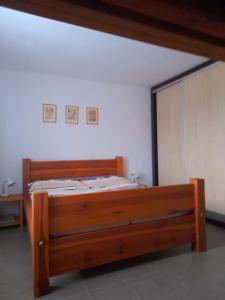 1 dormitorio con cama de madera y espejo en Apartmán u Zdeňků, en Modrava