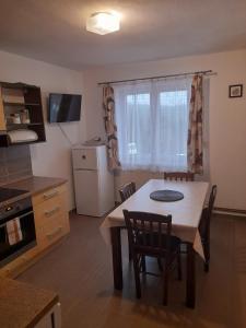 a kitchen and dining room with a table and chairs at Apartmán u Zdeňků in Modrava