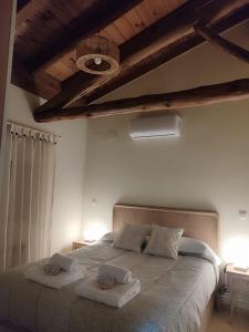 1 dormitorio con 1 cama grande y 2 toallas. en La casita de Ra, en Castillo de Bayuela