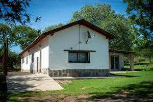 un edificio blanco con techo marrón en Posta Los Reartes en Los Reartes