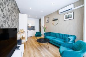 un soggiorno con divano blu e tavolo di Nice Renting - OFFENBACH - Luxury Apartment Fully Equipped Center a Nizza