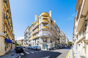 un alto edificio bianco su una strada cittadina con auto parcheggiate di Nice Renting - OFFENBACH - Luxury Apartment Fully Equipped Center a Nizza