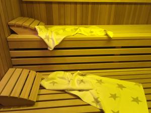 a sauna with a bed and a bench with yellow sheets at B&B Hotel Goldener Hahn - Guesthouse Hirsch Baiersbronn in Baiersbronn