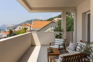 a balcony with chairs and a view of a city at Apartments aMare in Dubrovnik