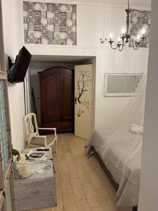 ein Schlafzimmer mit einem Bett, einem Stuhl und einem Kronleuchter in der Unterkunft La Siciliana-di fronte la Cattedrale in Palermo