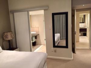 a bedroom with a bed and a mirror on the wall at Apartment in Sandton in Johannesburg +12 photos