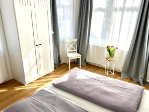 1 dormitorio con 1 cama, 1 silla y 1 ventana en Hus an de Waterkant, en Juist