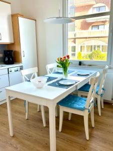 una mesa blanca y sillas en una cocina con ventana en Hus an de Waterkant, en Juist