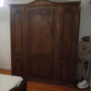 a wooden cabinet in the corner of a bedroom at Mall view in Alexandria