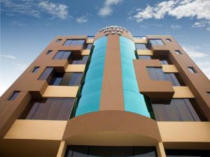 un edificio alto con un cielo azul en el fondo en Palmetto Hotel Business La Perla en Lima