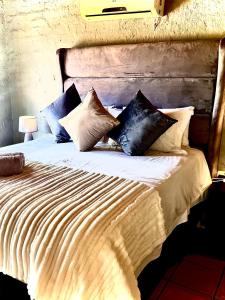 a large bed with many pillows on it at Majuli River House in Marloth Park