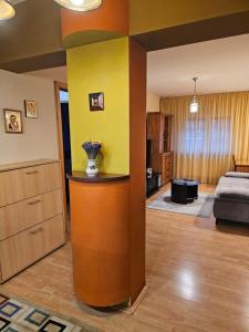 una sala de estar con una pared amarilla y un dormitorio en David Accommodation Deva, en Deva