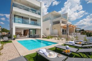 an image of a house with a swimming pool at Luxury Seaside Villa L'Amour with pool in Sibenik - Zaboric in Zaboric