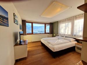 - une chambre avec un lit et une grande fenêtre dans l'établissement Apartments am See, à Egg am Faaker See