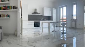 a white kitchen with a table and some chairs at B&B mare mio in Pescara