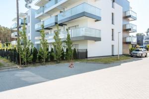 a woman sitting on the street in front of a building at Blue Sea in Pogorzelica