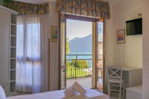 1 dormitorio con puerta que da a un balcón en Hotel Garda Bellevue, en Limone sul Garda