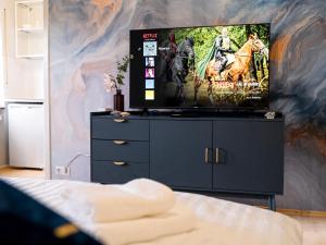 a living room with a tv on a dresser at City Heart - 2min to station in Ludwigshafen am Rhein