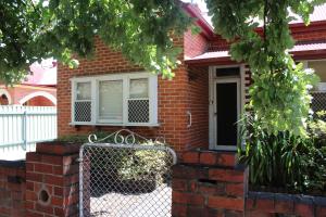 a brick house with a fence in front of it at The Cosy House - Central Albury in Albury
