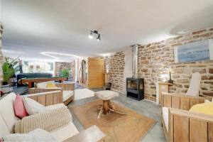 uma sala de estar cheia de mobiliário e uma parede de tijolos em Piscine Spa et Sauna Privé em Uzemain