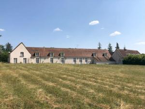 a large house with a field in front of it at Maison pour 15 personnes - Piscine - 50 min /Paris in Poigny-la-Forêt