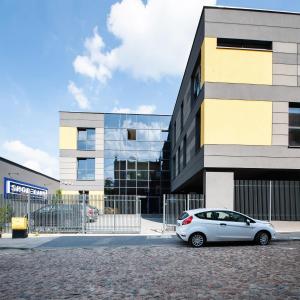 a white car parked in front of a building at Nowoczesne Apartamenty Stare Miasto in Częstochowa