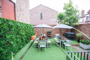 a patio with tables and chairs and umbrellas at Georgian Apartment Catharine St in Liverpool