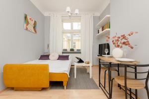 a bedroom with a bed and a desk and a table at Sunny Studio Lwowska Street Metro by Renters in Warsaw