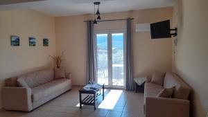 a living room with two couches and a tv at Rodanthy I in Katelios