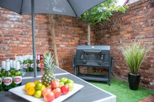 a table with fruit and a grill with an umbrella at Georgian Apartment Catharine St in Liverpool