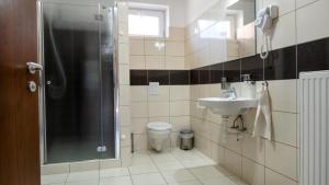a bathroom with a shower and a sink and a toilet at Family Apartman in Eplény +75 photos