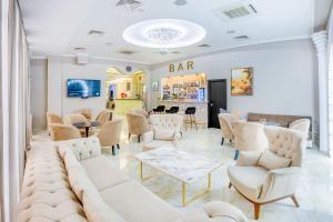 salon z białymi krzesłami i stołami oraz bar w obiekcie Cron Palace kosher Tbilisi Hotel w mieście Tbilisi City