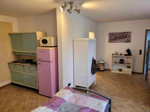 a room with a kitchen with a bed and a refrigerator at Fifties Apartment Bechhofen in Bechhofen