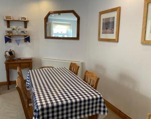 Un comedor con una mesa con mantel a cuadros. en Tenby Cottage with Parking, en Tenby 13 fotos más