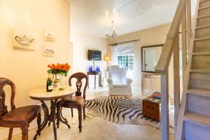 a living room with a table and a zebra rug at Devon Castle Orchard Cottage in Stellenbosch