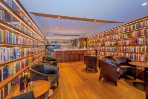 a library with leather chairs and bookshelves at Ambassade Hotel in Amsterdam