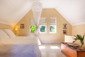 una camera con un grande letto e due finestre di Devon Castle Orchard Cottage a Stellenbosch Altre 15 foto