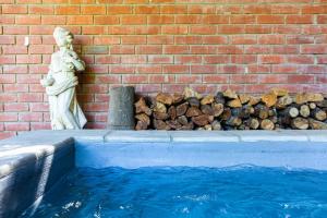 a statue of a woman next to a brick wall at Devon Castle Orchard Cottage in Stellenbosch