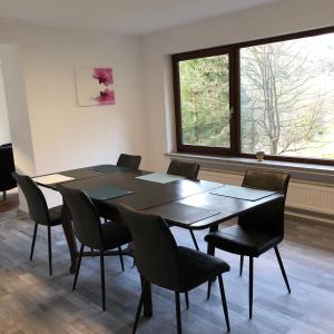 a conference room with a table and chairs and a window at FeWo Wald Idyllika in Willingen