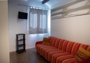 uma sala de estar com um sofá vermelho e uma televisão em Casa Loredana em Veneza