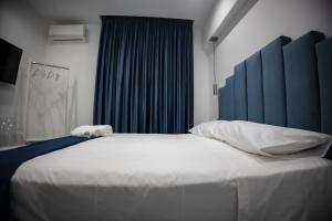a bedroom with a large white bed with a blue headboard at FP Suite in Naples