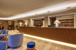 a hotel lobby with a bar and blue chairs at Hotel Nasco in Milan