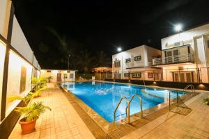 a swimming pool at night next to a building at Yuvraj Heritage Shelter Resort in Hosa Kannambādi