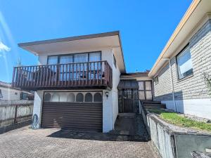 a house with a balcony and a garage at Available Now! Family home near Redwood Forest in Rotorua