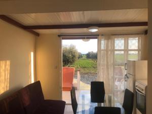 a living room with a table and a refrigerator at MERSINERA Paradise Garden NOAH HOUSE in Kivisil